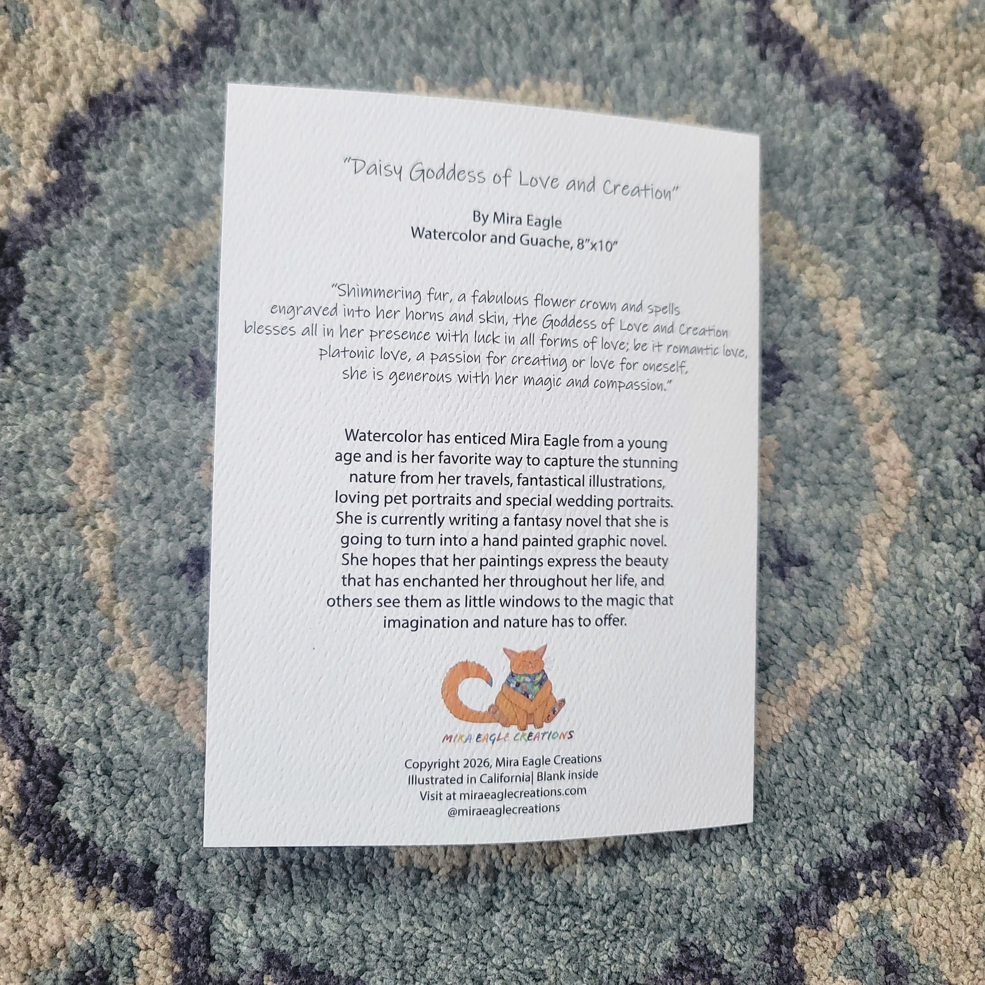 White greeting card with text titled "Divine Goddess of Love and Creation" on a textured blue and gray fabric background.