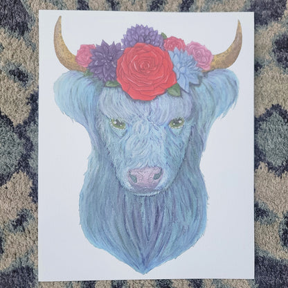 Watercolor highland cow with blue fur wearing a floral crown of red, purple, and pink flowers.